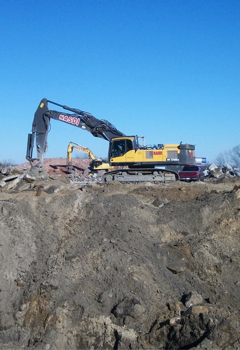 excavator on top of a dirt mound