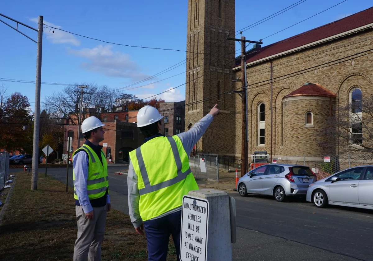 two people on sidewalk surveying a property